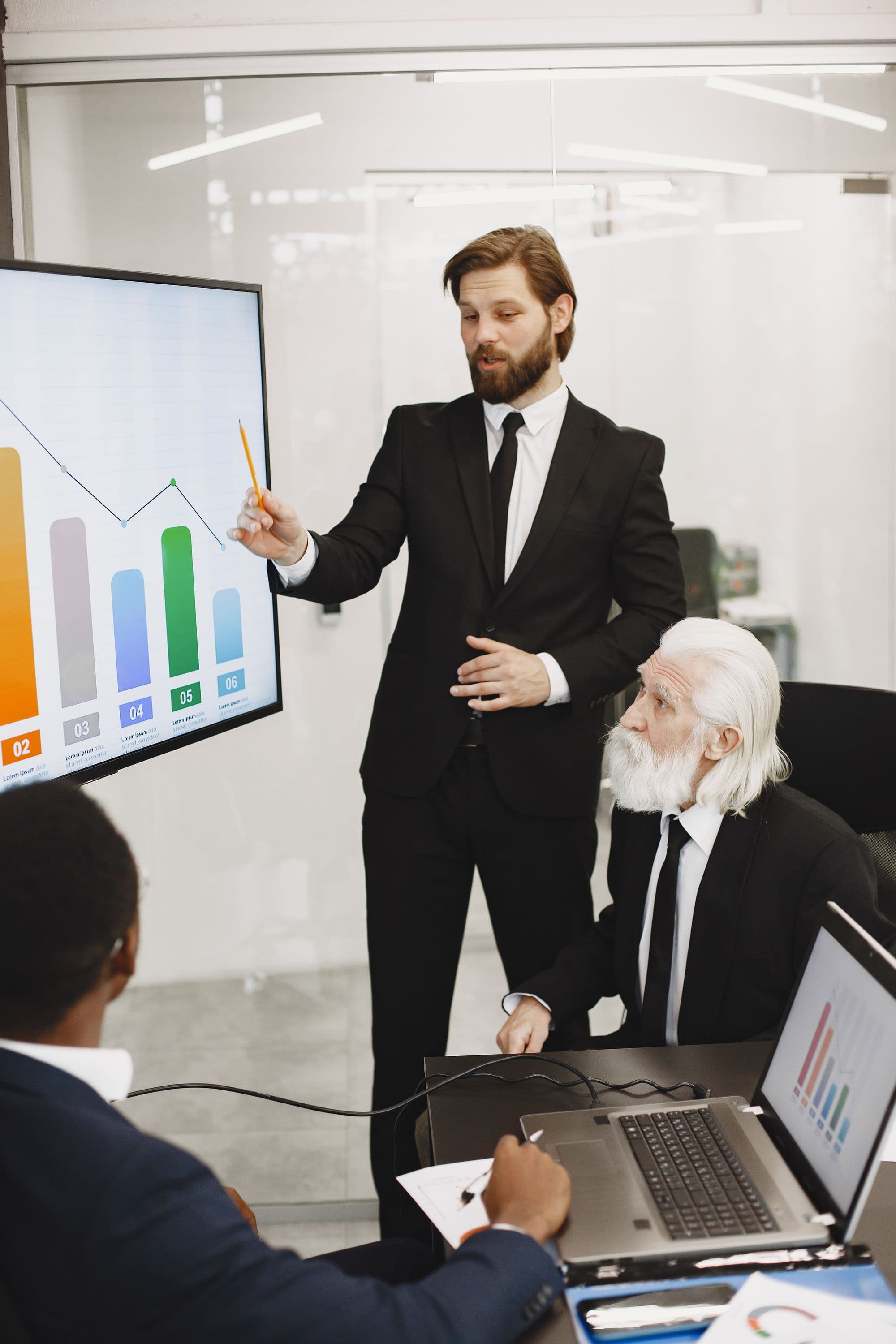 Business professionals discussing a presentation of charts in a meeting room