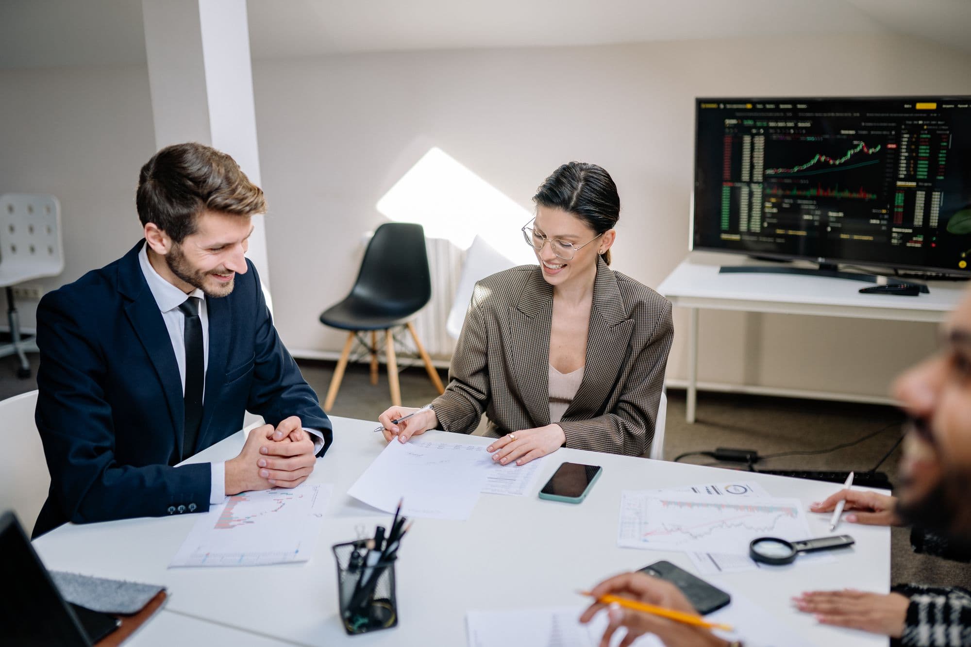 Colleagues discussing charts and data together during an office meeting