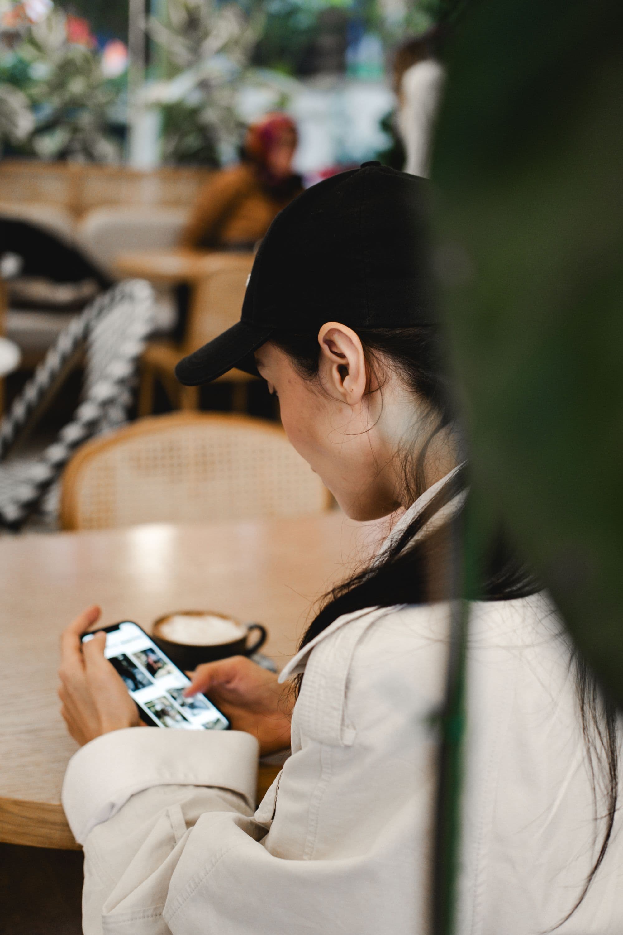 A woman quietly checking her phone over coffee in a café